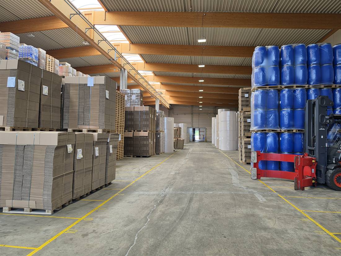 Lagerhalle mit Kartonagen, Paletten und Fässern